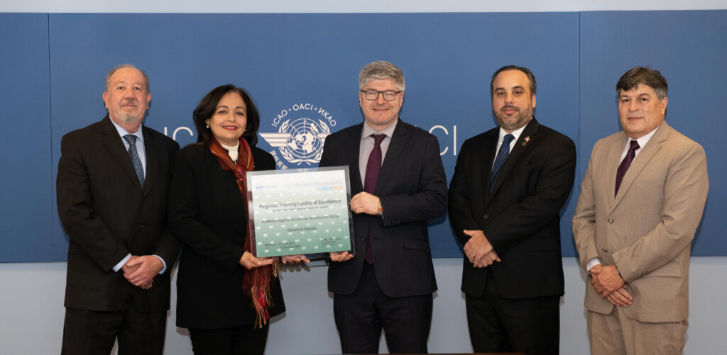 El secretario general de la OACI, Juan Carlos Salazar, entrega la recertificación como Centro Regional de Excelencia en Instrucción a la Clara Fernández, directora de la ASCA, le acompañan funcionarios de la organización internacional.