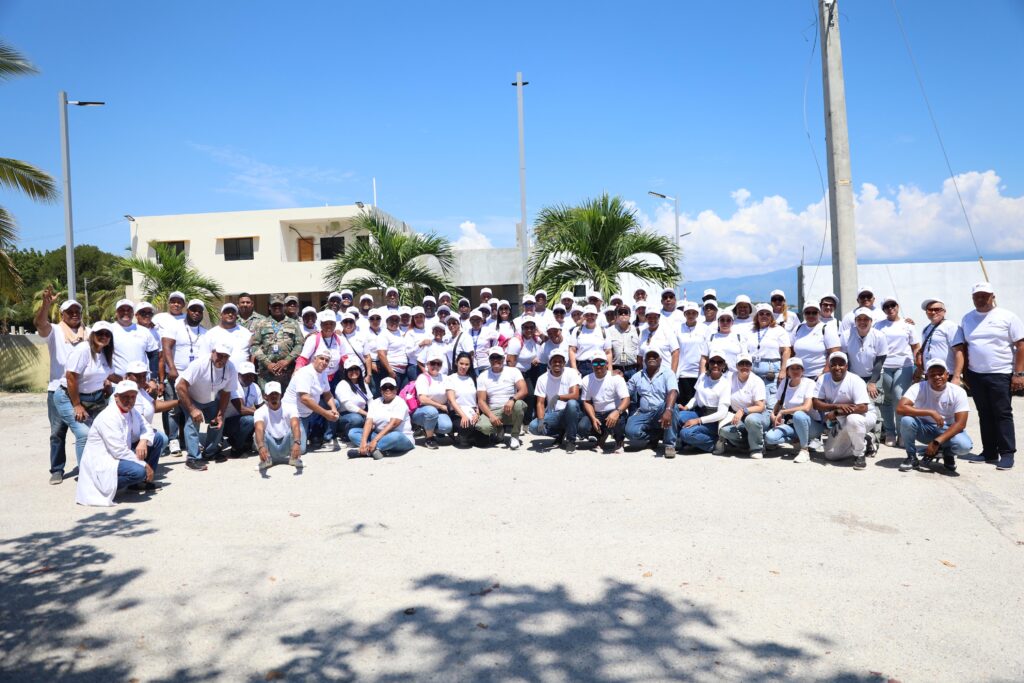Decenas de servidores del IDAC tras la intensa jornada de limpieza de la playa de Barahona realizada el sábado 4 de octubre, cumpliendo  el Programa de Responsabilidad Social de la institución, encabezada por el director de Comunicaciones, Claudio Martínez Turbí.