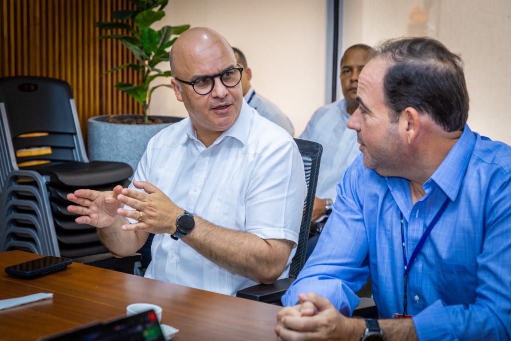 El director general del Instituto Dominicano de Aviación Civil (IDAC), conversa con Giovanni Rainieri, jefe de Operaciones del Lado Airside del Aeropuerto Internacional de Punta Cana, durante una jornada para evaluar los avances de los proyectos de modificación y segregación de las dos pistas, así como de la Reestructuración del Espacio Aéreo Dominicano (READ), en esa terminal aérea.