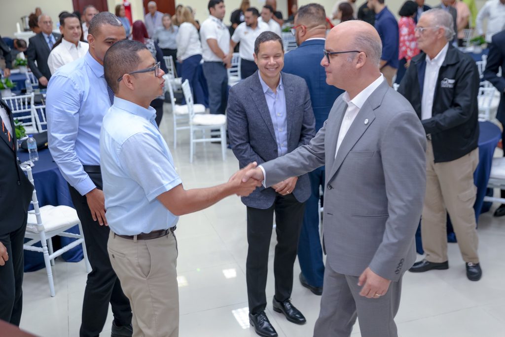 El director general del IDAC, Igor Rodríguez Durán, saluda a Albert E. Lara Calvo, piloto e instructor de vuelo, expositor del primer módulo del seminario. Al fondo, William Alsina Núñez, director de Navegación Aérea.